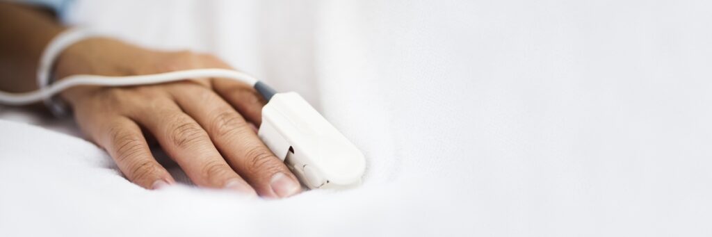 patient wearing pulse oximeter on their finger